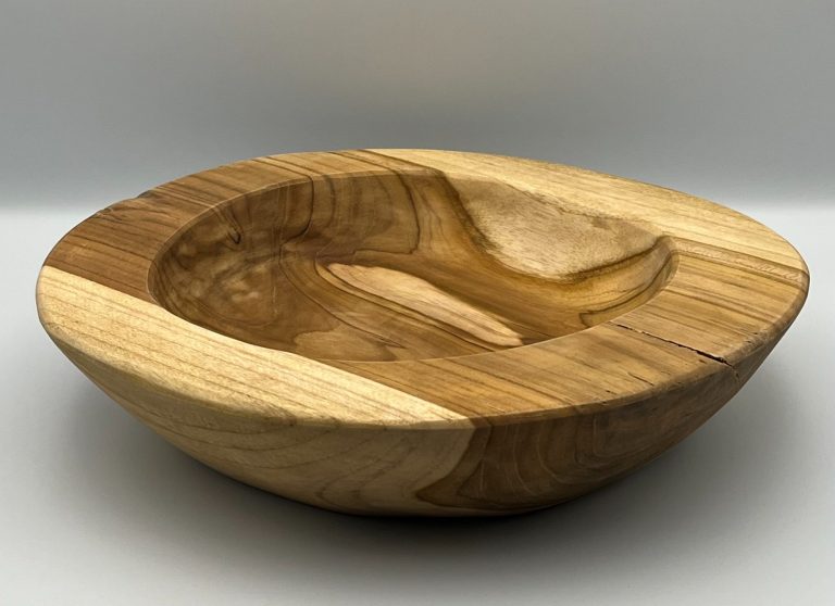 A handcrafted wooden bowl with a smooth, curved design and contrasting wood patterns.