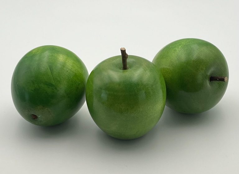 Hand painted wooden green apples with small brown stems.