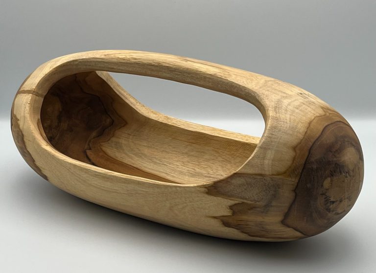 Carved wooden Trug with a curved handle, featuring smooth and natural wood grain.